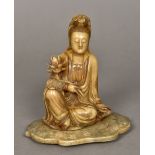 A Chinese carved Shoushon stone figure of Guanyin Modelled seated holding a lotus flower.