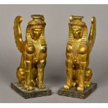 A pair of carved wooden gilt decorated candlesticks Worked as sphinxes. 30 cm high.
