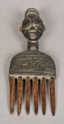 An African tribal carved wooden comb The handle carved as a mask. 26.5 cm long.