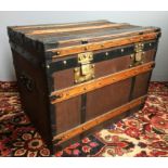 A vintage travelling trunk Of hinged rectangular form, with iron bindings and brass rivets,