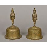 A pair of Eastern brass hand bells Each with engraved bowl and figural cast handle. 18.5 cm high.