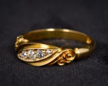 An 18K yellow gold five stone diamond ring Of scrolling lozenge form.