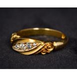 An 18K yellow gold five stone diamond ring Of scrolling lozenge form.