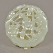 A Chinese pierced and carved white jade phoenix and peony pendant 5 cm diameter.