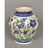 A Qajar pottery vase Typically decorated with floral sprays. 18 cm high.