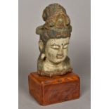 A Chinese carved wood and polychrome decorated Buddha's head Mounted on a later plinth base.