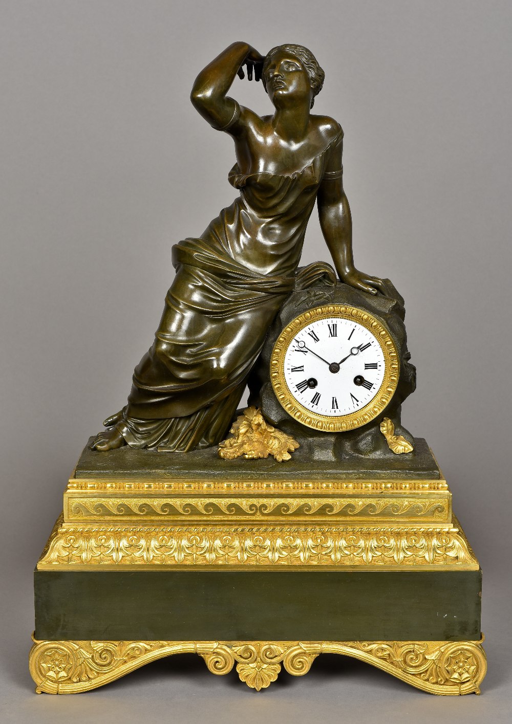 A 19th century gilt bronze and patinated bronze mantel clock Surmounted with a scantily draped