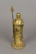A Chinese gilt bronze figure of a deity Modelled standing holding a pearl and a staff with pierced