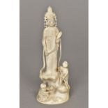 A 19th century Chinese carved ivory figural group Formed as Guanyin wearing a headdress with two