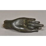 An antique patinated cast bronze hand of Buddha The open palm decorated with a flower. 19 cm long.