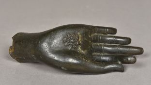 An antique patinated cast bronze hand of Buddha The open palm decorated with a flower. 19 cm long.