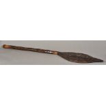 A North American Native Indian wooden paddle The blade carved with two figures rowing a canoe.