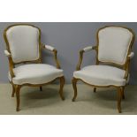 A pair of French upholstered open armchairs Each with a padded back and twin scrolling padded open