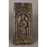 A 15th century carved oak panel Worked with a Bishop holding a crozier and standing beneath a