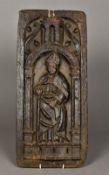 A 15th century carved oak panel Worked with a Bishop holding a crozier and standing beneath a