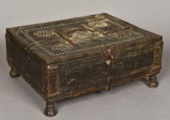 An antique North African chip carved casket With part hinged cover, standing on inverted cup feet.