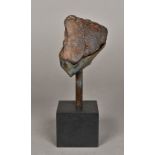 A stone meteorite fragment Mounted on a display stand (by reputed recovered from the Sahara Desert).