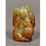 A Chinese carved celadon and russet jade monkey 5.5 cm high.