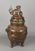 A large Oriental patinated bronze koro The pierced top surmounted with a dog-of-fo finial,