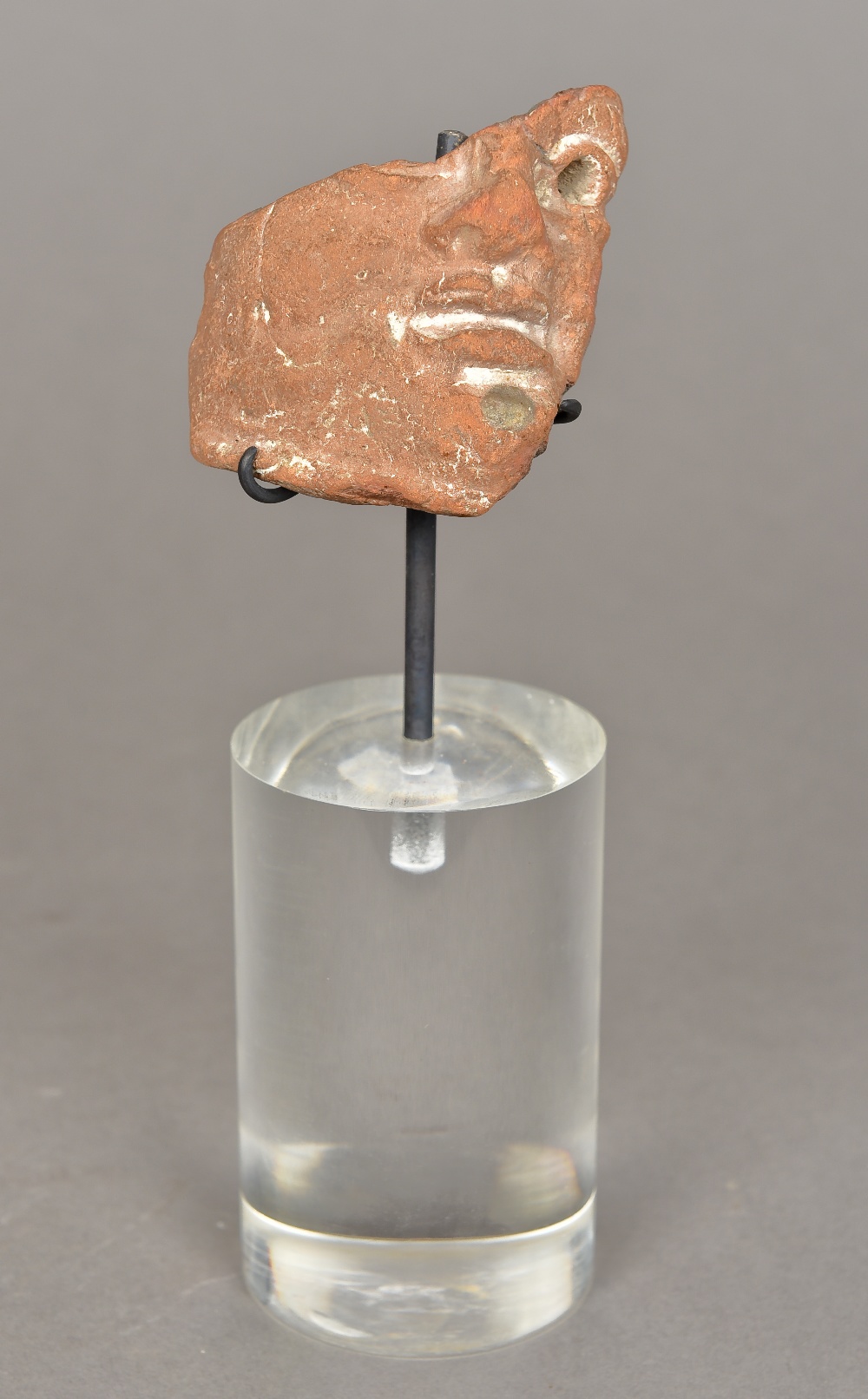 A terracotta fragment, possibly Roman Mounted on a perspex base. 20 cm high overall.