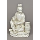 A Chinese blanc de chine porcelain figure Worked as a fisherman returning with his catch;