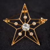 A 14K gold and diamond brooch Of pierced star form centred with a claw set diamond. 2.5 cm wide.