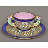 A Canton enamel tea bowl and saucer The bowl with twin scalloped pierced handles,