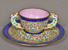 A Canton enamel tea bowl and saucer The bowl with twin scalloped pierced handles,