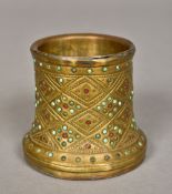 A Persian brass hookah base Decorated with inset turquoise and ruby cabochons. 6.5 cm high.