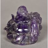 A Chinese carved amethyst Buddha Modelled recumbent. 6.5 cm high.