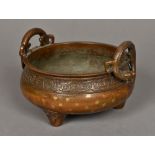 A Chinese cast bronze censor The handles modelled as dragons above a stylised strapwork band,