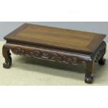 An 18th/19th century Chinese hardwood coffee table The panelled rectangular top above the scroll