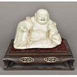A Chinese blanc de chine porcelain Buddha Modelled seated holding a fruit,