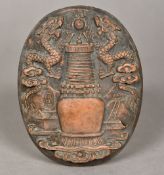 A Chinese terracotta plaque Worked with dragons flanking a flaming pearl and architectural vase.