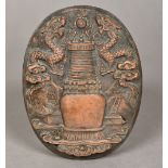 A Chinese terracotta plaque Worked with dragons flanking a flaming pearl and architectural vase.