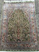 A Turkish silk prayer rug The green mihrab field enclosing a tree of life and exotic birds within