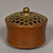 A small Chinese patinated bronze censor Of waisted cylindrical form with a removable pierced lid,