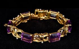 An 18 K gold, diamond and amethyst bracelet Of pierced scrolling floral form. 19 cm long.
