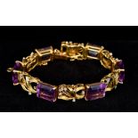 An 18 K gold, diamond and amethyst bracelet Of pierced scrolling floral form. 19 cm long.