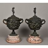 A pair of patinated bronze lidded urns Each of twin handled form with classical relief decorations,