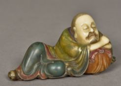 A Chinese carved Shoushon stone Lohan Modelled recumbent with polychrome decoration. 13.5 cm wide.