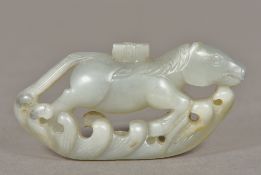 A Chinese carved white jade mythical horse Worked above stylised waves. 8 cm wide.