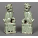 A pair of Chinese celadon dogs-of-fo Each typically modelled with a foot on a ball. Each 11.