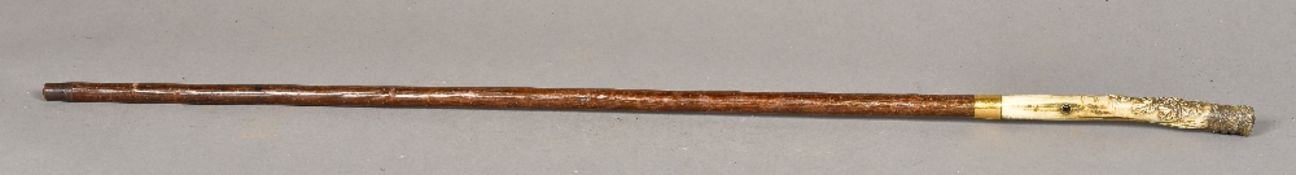 A Japanese carved bone handled walking stick The handle carved with bird amongst floral sprays,