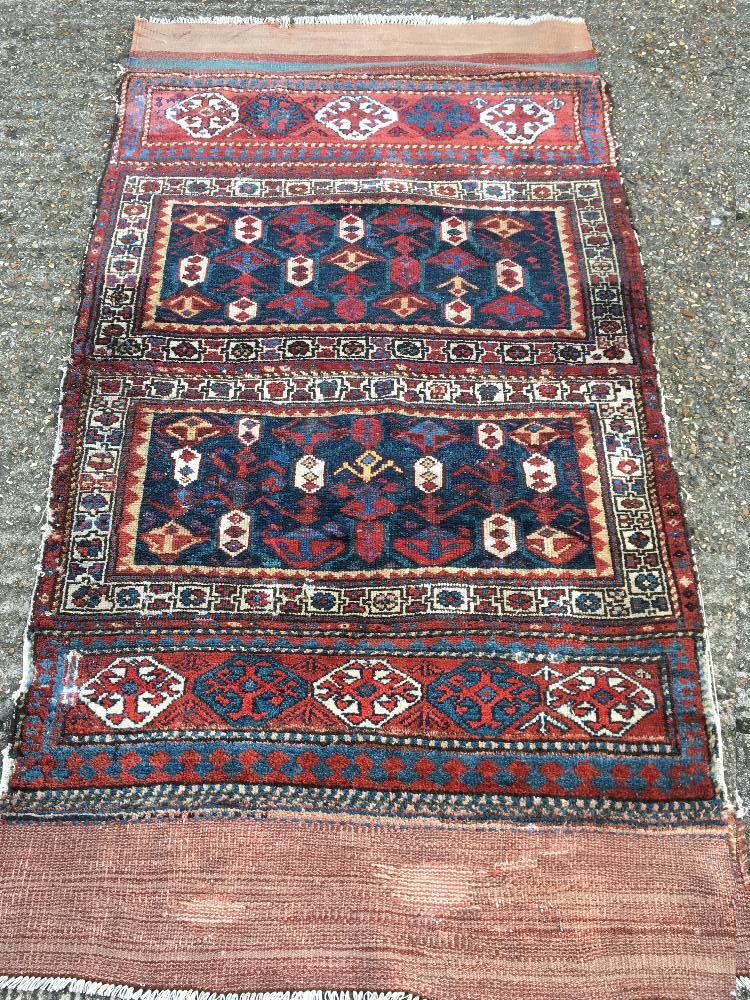 A tribal wool rug Typically worked with geometric motifs, secured with kilim skirts. 210 x 112 cm.