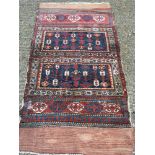 A tribal wool rug Typically worked with geometric motifs, secured with kilim skirts. 210 x 112 cm.