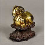 A Chinese cast gilt bronze figure of a ram Modelled recumbent,