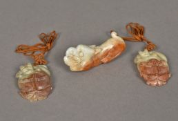 A Chinese carved russet jade model of a dog-of-fo Together with two carved russet jade pendants.
