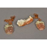 A Chinese carved russet jade model of a dog-of-fo Together with two carved russet jade pendants.