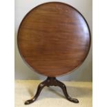 A George III mahogany tilt-top tripod table The dished top above the birdcage movement,